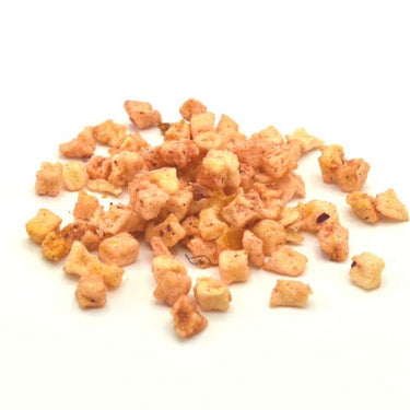A small pile of light brown, diced dried apple pieces is scattered on a white background—an ideal fruity ingredient for blending into Peach SereniTea Loose Leaf Herbal Tea 🍑 or making a refreshing caffeine-free iced tea.